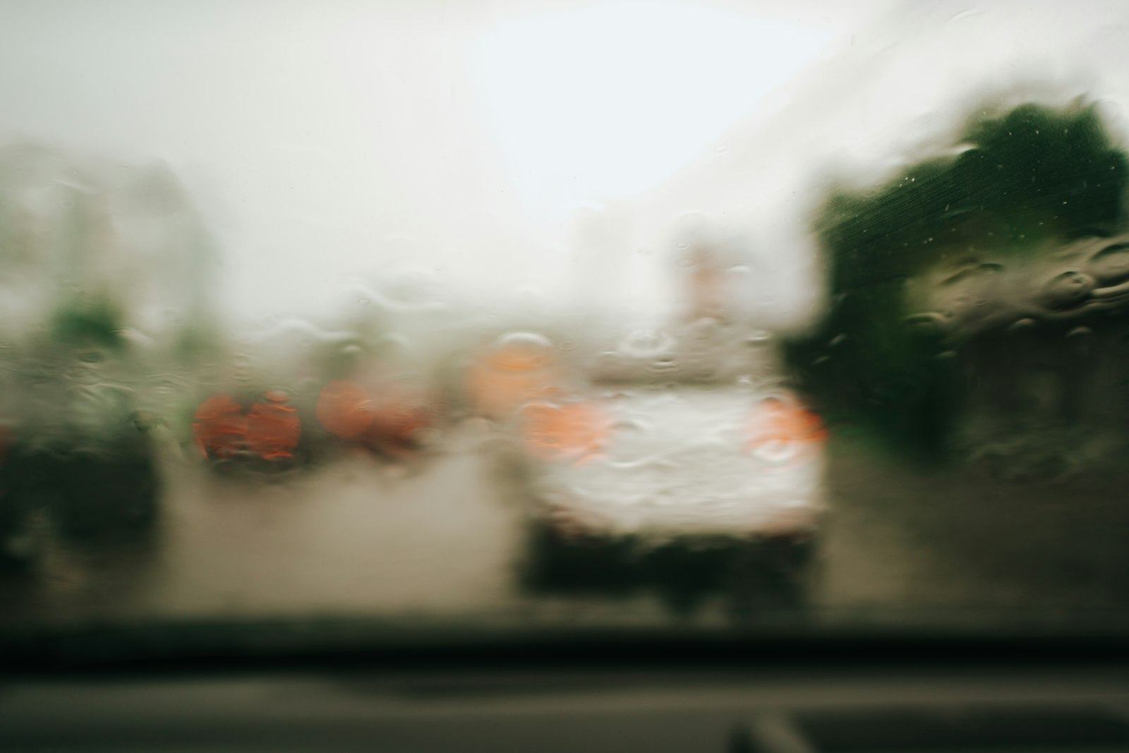 雨天隔著擋風玻璃看出去,前方車流與車燈一片模糊